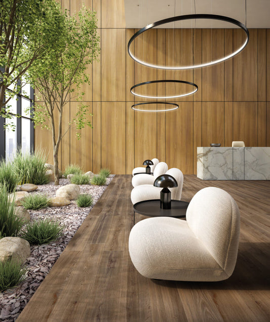 EnergieKer Woodbreak 'Ebony', bruine houtlook vloertegels in een lounge met houten lattenwand, ronde hanglampen en binnentuin