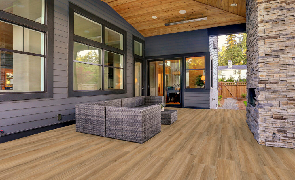 EnergieKer Woodbreak 'Oak', eikenkleurige houtlook vloertegels op een terras met rieten zitgroep en natuurstenen wand
